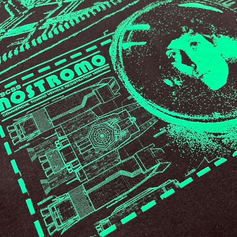 May include: A black t-shirt with a green graphic print of a spaceship with the text "Nostromo" and "Commercial Towing Vehicle Registration 18082409".
