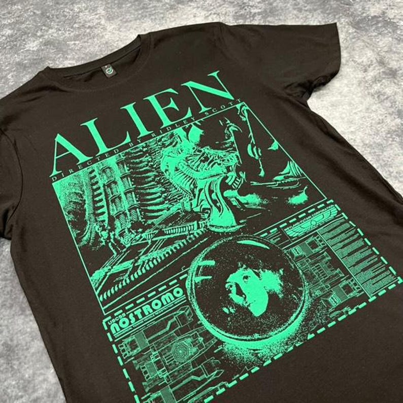 May include: Black t-shirt with a green graphic print of the movie "Alien" directed by Ridley Scott. The graphic includes the text "Alien", "Directed by Ridley Scott", "USCSS Nostromo", and a scene from the movie.