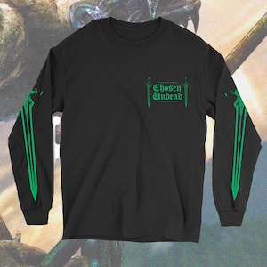 Peut inclure: T-shirt à manches longues noire avec des graphismes d'épées vertes sur les manches et le texte "Chosen Undead" sur le devant.