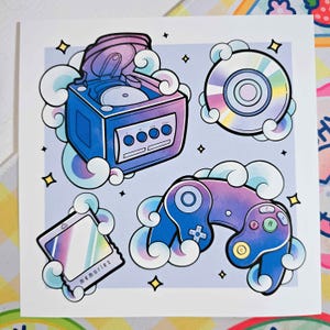 May include: A digital art print featuring a purple and blue GameCube console, a purple and blue GameCube controller, a silver GameCube disc, and a GameBoy Advance cartridge. The items are surrounded by white clouds with a light blue background. The text "memories" is written on the GameBoy Advance cartridge.