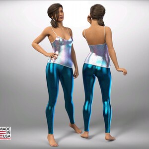 May include: A woman is wearing a white iridescent tank top and blue leggings with a scaly pattern. The leggings are form-fitting and have a shiny finish.