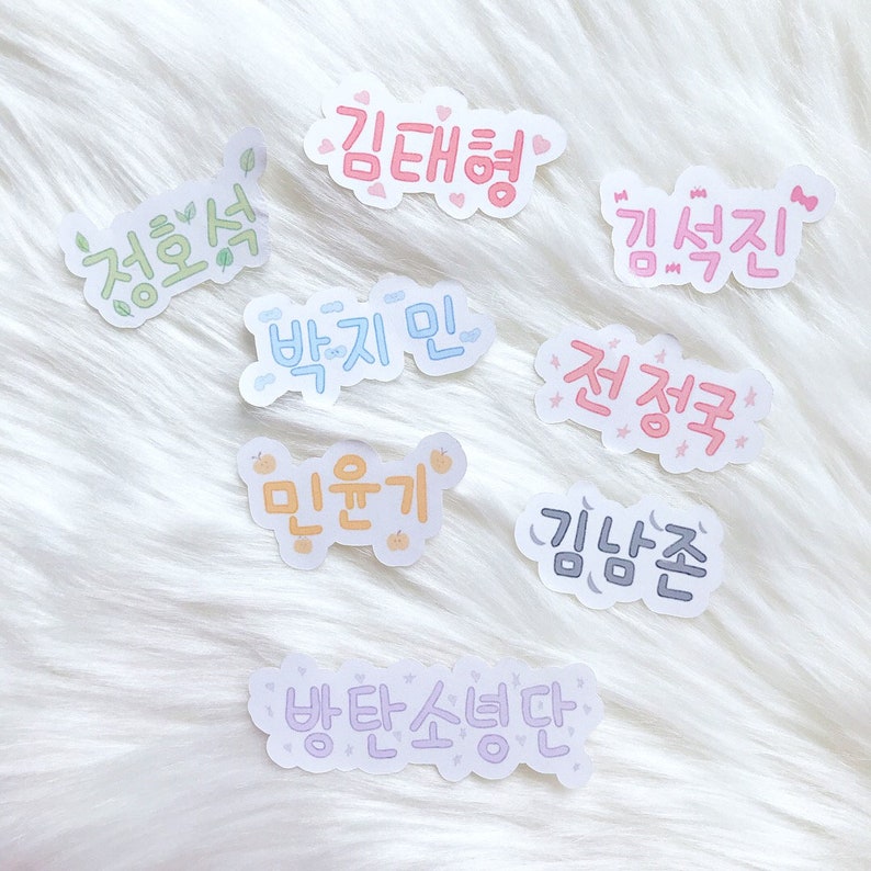 May include: A set of nine colorful stickers with Korean text. The stickers feature various phrases, including "Kim Taehyung", "Jeon Jungkook", "Park Jimin", and "Min Yoongi".