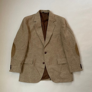 May include: A beige tweed blazer with brown leather elbow patches and a brown lining. The blazer has a two-button closure and two front pockets.