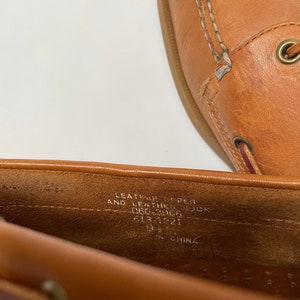 May include: Close-up of the inside of a brown leather shoe. The shoe is labelled "Leather Upper and Leather Sock" and "9 1/2" in size. The shoe was made in China.