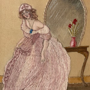 Puede incluir: Obra bordada que representa a una mujer con un vestido rosa de pie frente a un tocador con un espejo y un jarr&oacute;n de flores rojas. La mujer lleva una gorra blanca y un collar con un colgante azul.