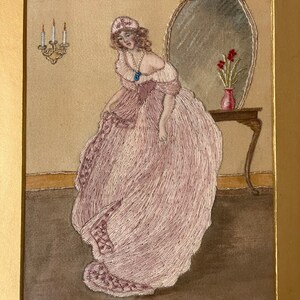 Puede incluir: Una mujer con un vestido rosa y un gorro blanco se encuentra de pie frente a un espejo. Est&aacute; mirando hacia abajo a su vestido. Hay un jarr&oacute;n con flores rojas sobre una mesa junto al espejo.