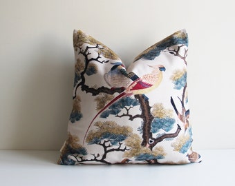 May include: A white throw pillow with a colorful bird and pine tree design. The birds are red, yellow, blue, and green. The pine trees are green and brown.