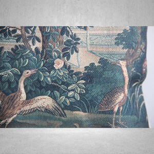 以下が含まれることがあります： 緑と茶色のタペストリーには、庭園の中に2羽の鳥が描かれています。鳥はスタイリッシュで、長い首とくちばしをしています。庭園は緑の葉と1つのピンクの花でいっぱいです。