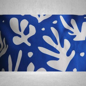 May include: Blue and white fabric with a repeating pattern of abstract white leaves on a blue background.