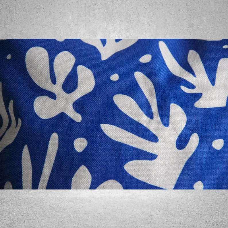 May include: Blue and white fabric with a repeating pattern of abstract white leaves on a blue background.