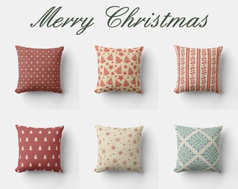 May include: Six decorative throw pillows with Christmas-themed patterns. Designs include stars, trees, and floral stripes in red and cream colors. The words "Merry Christmas" are written in green script above the pillows.