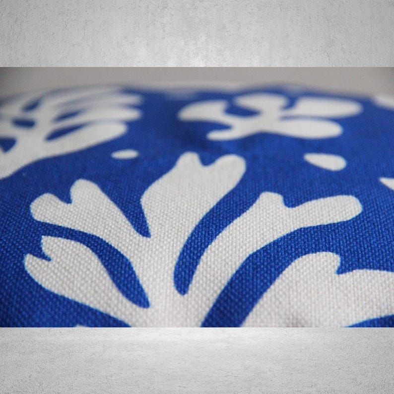 May include: Close-up of a blue and white patterned fabric with a floral design. The fabric is soft and textured, with a subtle sheen.
