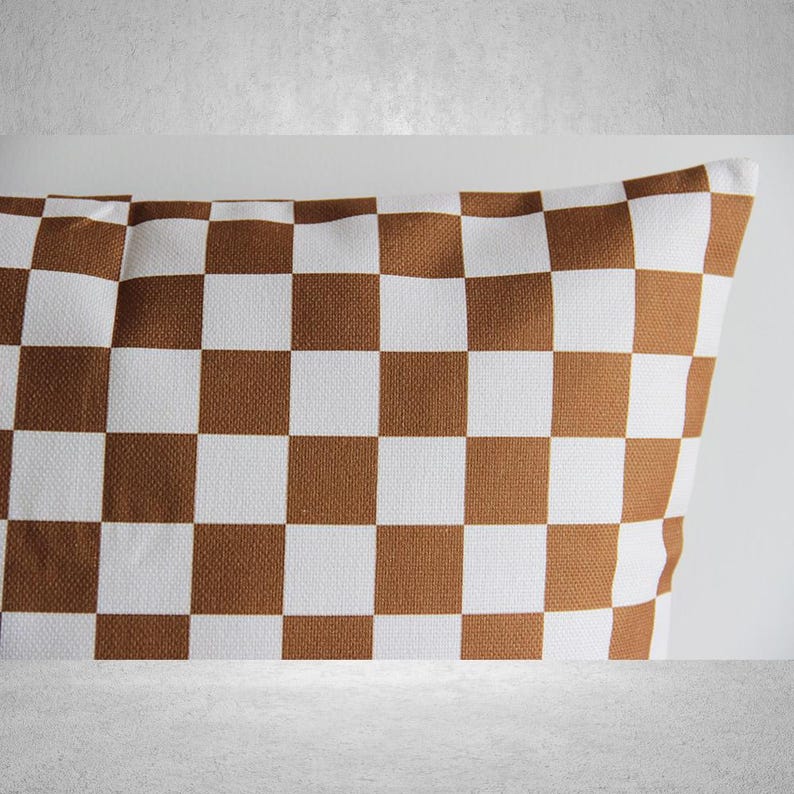 May include: A brown and white checkered throw pillow. The pillow is made of a soft, woven fabric.