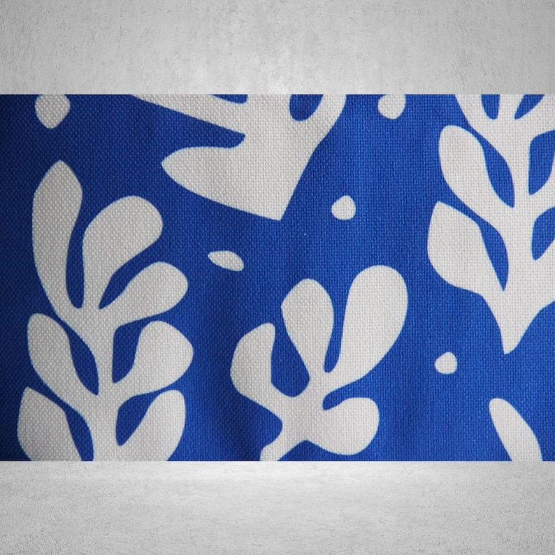 May include: Blue fabric with a white abstract floral pattern. The fabric has a textured surface.