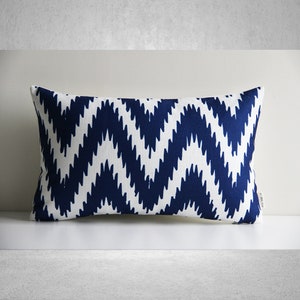 May include: A navy blue and white patterned cushion with a chevron design.