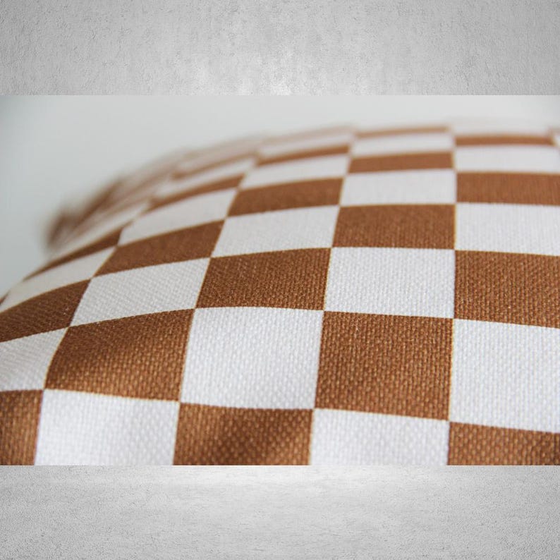 May include: A brown and white checkered pillow with a soft, textured fabric.