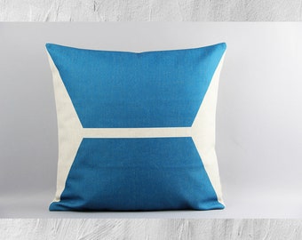 May include: A blue throw pillow with a white geometric design. The pillow is made of a soft, textured fabric.