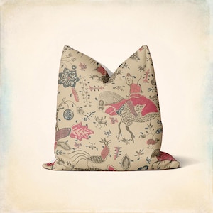 May include: A beige cushion with a red, black and white patterned design featuring stylised birds, flowers and animals. The pattern is reminiscent of traditional Indonesian batik.