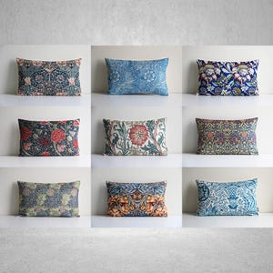 Könnte beinhalten: Neun rechteckige Kissen mit floralen Mustern in verschiedenen Farben, darunter Blau, Rot und Grün. Die Kissen sind in einem Raster von drei mal drei angeordnet und zeigen verschiedene Designs und Farbschemata. Die Kissen sind aus Stoff.