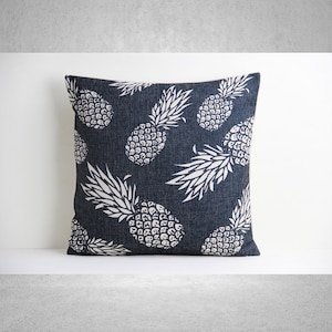 May include: A navy blue throw pillow with a white pineapple pattern. The pillow is made of a soft, comfortable fabric and is perfect for adding a touch of tropical style to your home.