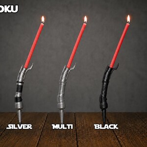 May include: Three curved candle holders in silver, multi-tone, and black finishes, each holding a lit red taper candle. The text DOOKU appears at the top left, with the labels SILVER, MULTI, and BLACK positioned below each respective holder.