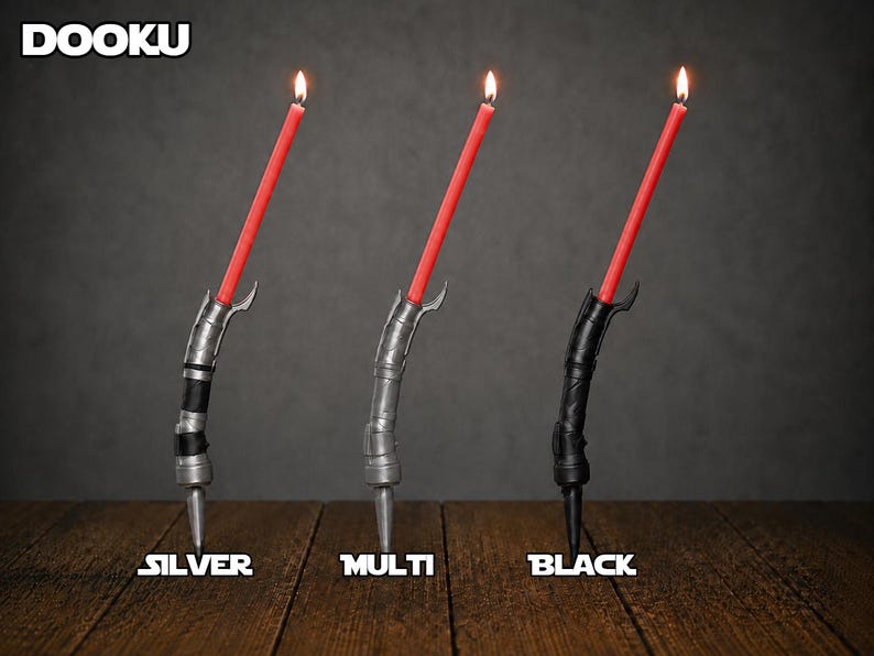 May include: Three curved candle holders in silver, multi-tone, and black finishes, each holding a lit red taper candle. The text DOOKU appears at the top left, with the labels SILVER, MULTI, and BLACK positioned below each respective holder.