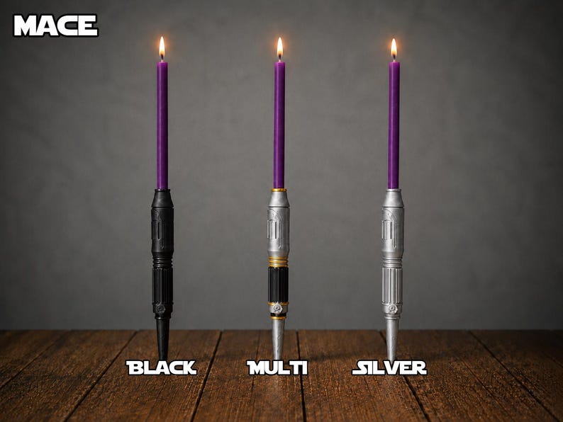 May include: Three lit purple taper candles held in vertical holders designed like lightsaber hilts. The holders are labeled MACE, with individual labels for BLACK, MULTI, and SILVER finishes. The hilts feature cylindrical, metallic-looking details.