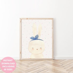 Op de afbeelding: Waterverfillustratie van een cr&egrave;mekleurig konijn met een blauwe strik, omlijst in een licht houten frame. De achtergrond is wit met pastelkleurige confetti. De tekst "INSTANT DOWNLOAD INCLUDING 35 SIZES" staat in een roze cirkel linksonder.