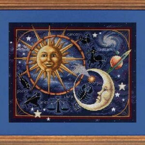 May include: A cross-stitch embroidery depicting the zodiac signs in a celestial scene with a sun and moon. The sun and moon are stylized with faces and the zodiac signs are arranged around them. The background is a dark blue with stars.