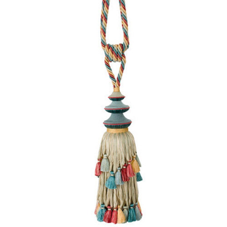 May include: A multi-colored tassel with a blue and gold pagoda-shaped top. The tassel is made of a beige fabric with multi-colored tassels hanging from the bottom.