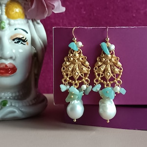 May include: Gold earrings with a delicate filigree design, featuring turquoise and pearl accents.