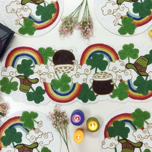 May include: Set of six white beaded placemats with a rainbow, shamrock, and leprechaun hat design. The placemats are perfect for St. Patrick's Day or any Irish-themed event.