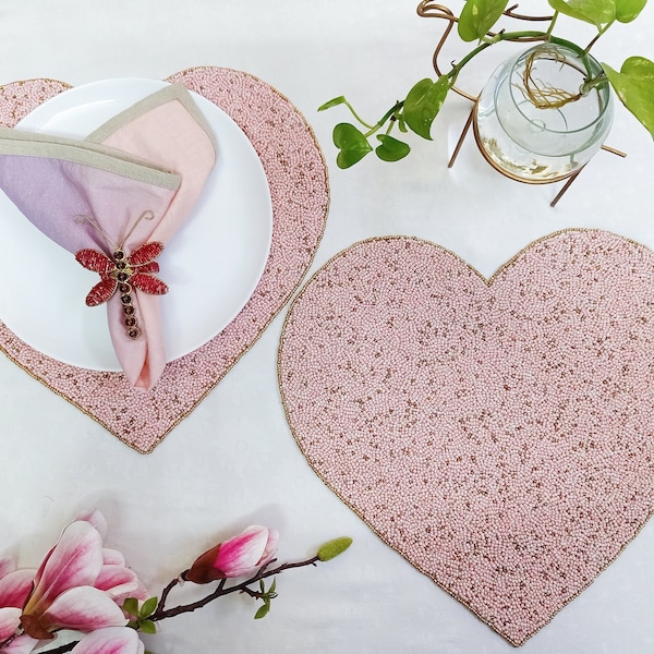 Cuentas rosas hechas a mano en forma de corazón en el mantel individual