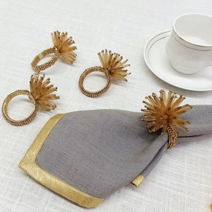 A set of 4 long gold bead napkin rings