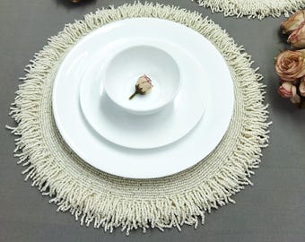 Off-white handmade beaded placemats with one-inch fringes.