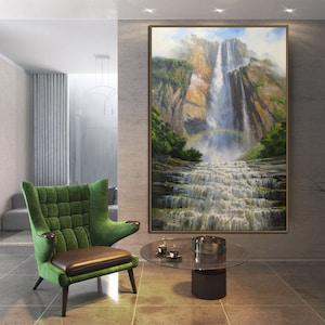 May include: A painting of a waterfall cascading down a rocky cliff face. Lush green foliage surrounds the waterfall, and a rainbow arches over the water. The painting is framed in a brown wood frame.