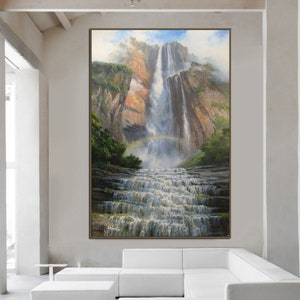 May include: A painting of a waterfall cascading down a rocky cliff face. Lush green foliage surrounds the base of the waterfall, and a rainbow arches over the water. The painting is framed in a brown wood frame.
