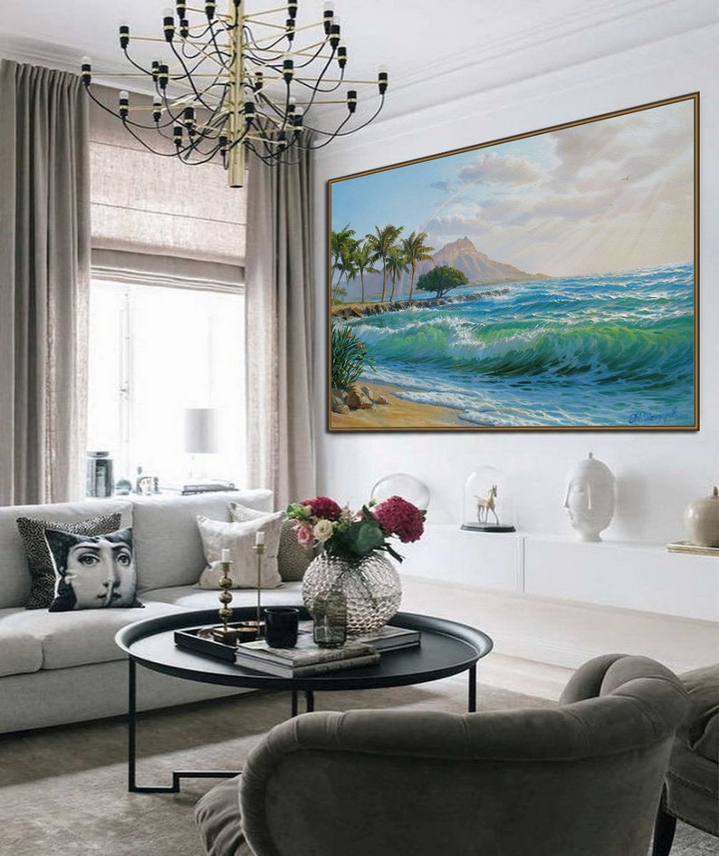 Puede incluir: Una pintura enmarcada de una escena de playa tropical con palmeras, una monta&ntilde;a en la distancia y olas azul turquesa rompiendo en la orilla.