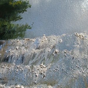 May include: Close-up of a textured, blue and white canvas painting. The paint is applied in thick strokes, creating a rough, uneven surface.