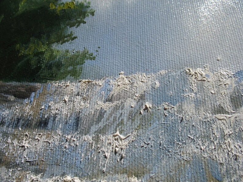 May include: Close-up of a textured, blue and white canvas painting. The paint is applied in thick strokes, creating a rough, uneven surface.