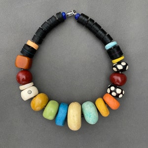 Opulenta collana con antiche perle africane in resina e osso, dischi di bachelite ed elementi realizzati a mano in carta riciclata e polvere di pietra