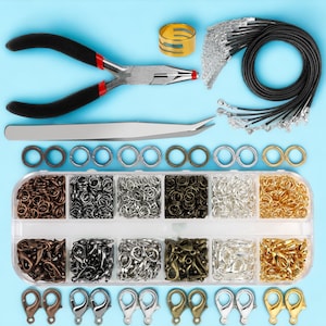May include: A set of jewelry making supplies including a variety of jump rings, lobster clasps, and chain in gold, silver, and bronze tones. The set also includes a pair of pliers, tweezers, and a roll of black cord.