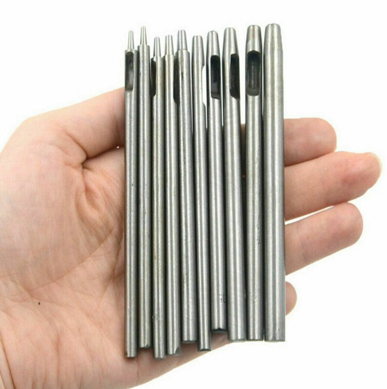 May include: Set of 10 silver metal hole punch tools with different sized holes. The tools are held in a hand.