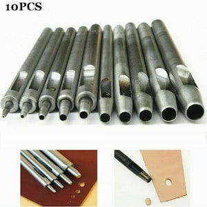 May include: Set of 10 silver metal leather hole punch tools. The tools are lined up in order of size, with the smallest on the left and the largest on the right. The tools are used to punch holes in leather for sewing or other crafts.
