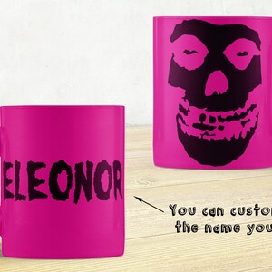 Puede incluir: Taza de cerámica rosa con un diseño de calavera negra en un lado y el nombre "ELEONOR" en el otro. Puedes personalizar con el nombre que quieras.