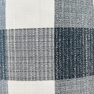 May include: A close-up of a white and black checkered fabric with a textured weave.