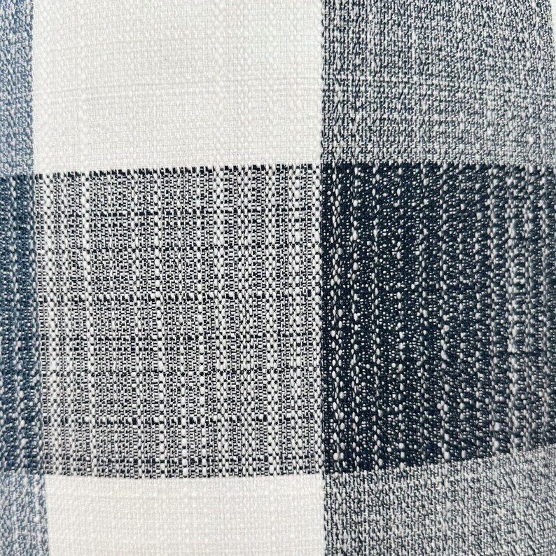May include: A close-up of a white and black checkered fabric with a textured weave.