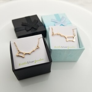 May include: Two small black gift boxes with gold constellation necklaces inside. The boxes are open and the necklaces are visible. The necklaces are in the shape of a constellation with a star at the end. The boxes have the text "littleSilverjeweler" printed on them.