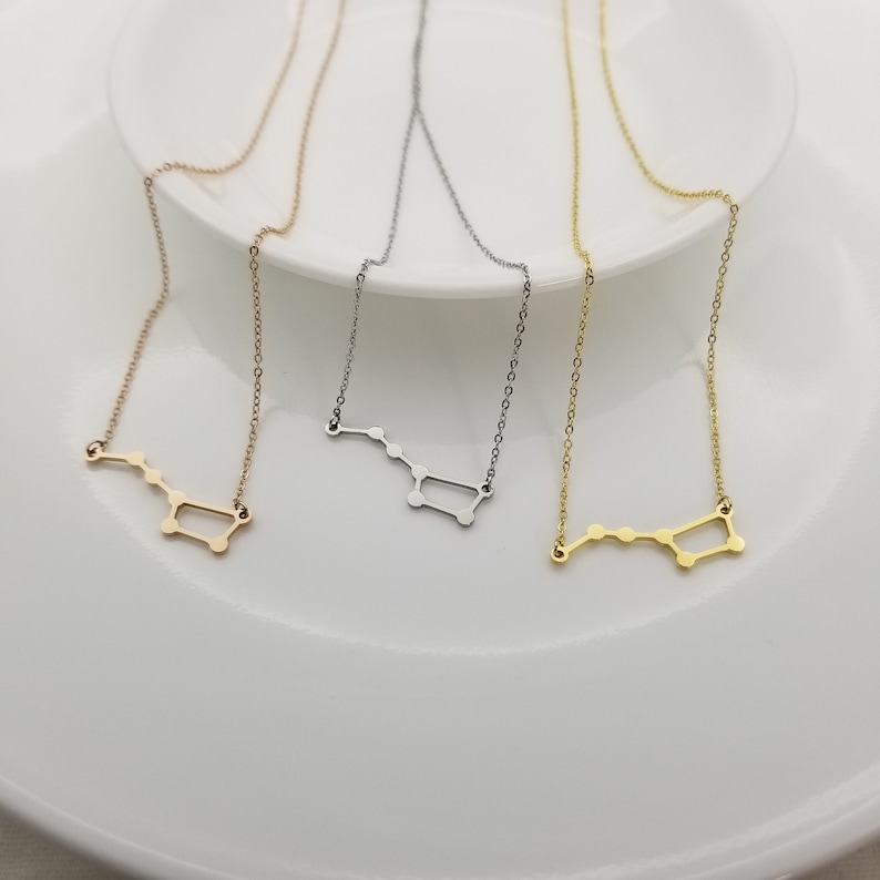 May include: Three delicate necklaces with a constellation design. The necklaces are silver, gold, and rose gold.