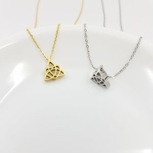 May include: Two delicate necklaces with Celtic knot pendants. One necklace has a gold pendant and the other has a silver pendant.